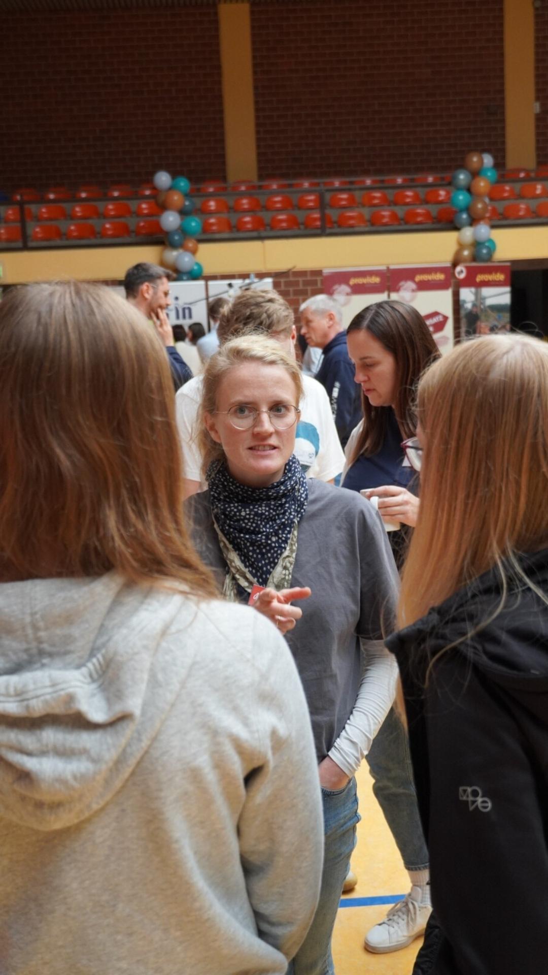 Besucher im Gespräch mit einer Missionarin auf der JUMIKO 2024